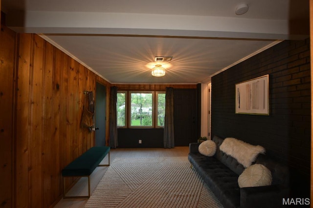 living room with crown molding, wood walls, brick wall, and beamed ceiling