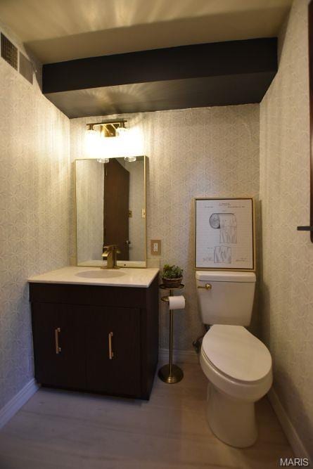 bathroom with vanity, toilet, and baseboards