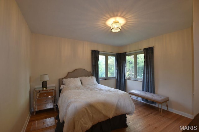 bedroom with wood finished floors and baseboards