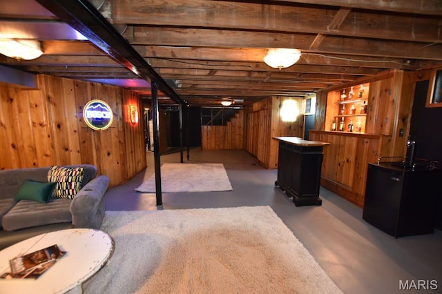 finished basement with a bar, fridge, and wooden walls