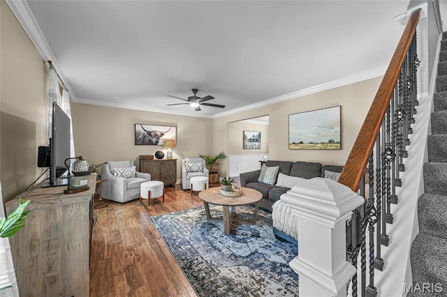 living room featuring ornamental molding, hardwood / wood-style flooring, a ceiling fan, and stairs