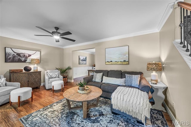 living room with crown molding, wood finished floors, ceiling fan, and baseboards