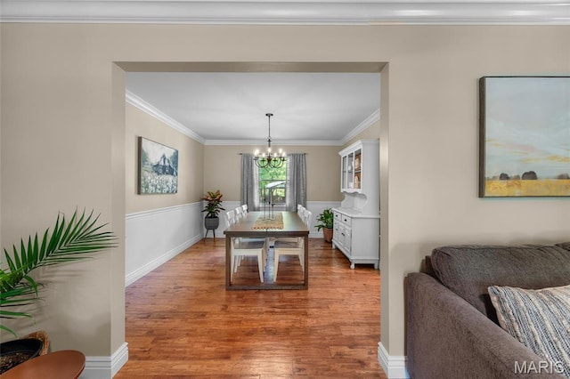 dining area featuring a chandelier, wood finished floors, and crown molding
