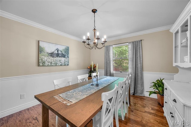 dining area featuring a chandelier, crown molding, wood finished floors, and baseboards
