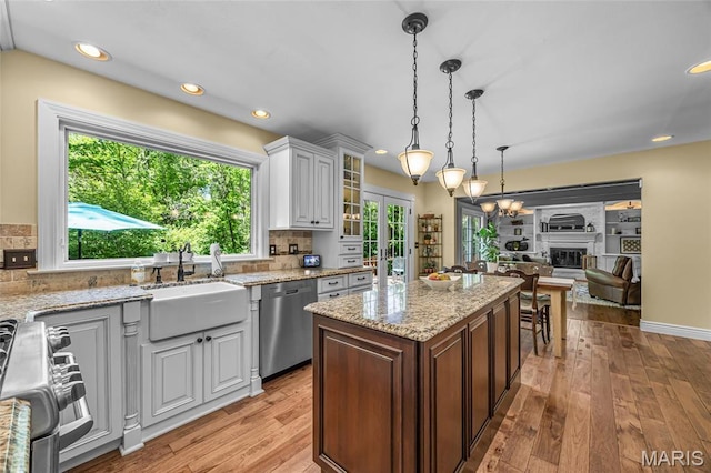 kitchen featuring stainless steel appliances, a sink, healthy amount of natural light, light wood-style flooring, and recessed lighting