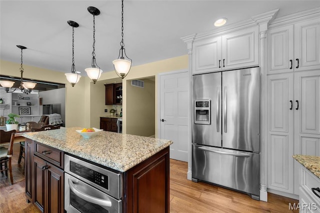 kitchen featuring stainless steel refrigerator with ice dispenser, dark brown cabinetry, and light wood-style floors