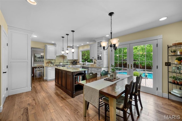 dining room featuring a chandelier, wood-type flooring, french doors, recessed lighting, and baseboards