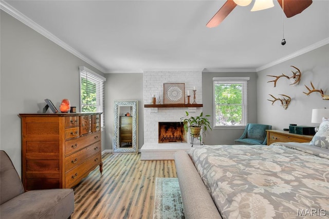 bedroom featuring multiple windows, crown molding, wood finished floors, a ceiling fan, and baseboards