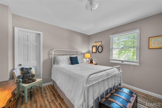 bedroom with wood finished floors and baseboards