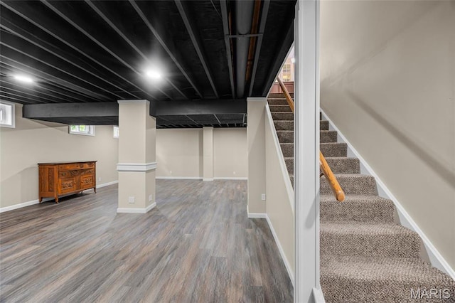 basement with wood finished floors, stairway, and baseboards
