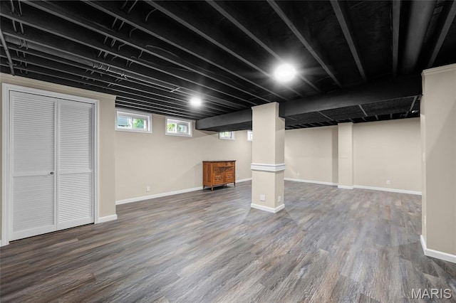 below grade area featuring dark wood-type flooring and baseboards