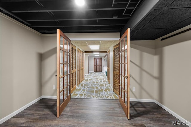 corridor with french doors, baseboards, and wood finished floors