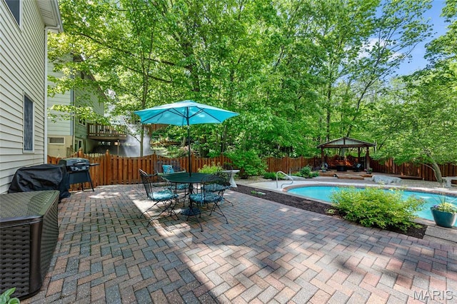 view of swimming pool with a gazebo, a fenced backyard, a patio area, area for grilling, and outdoor dining space