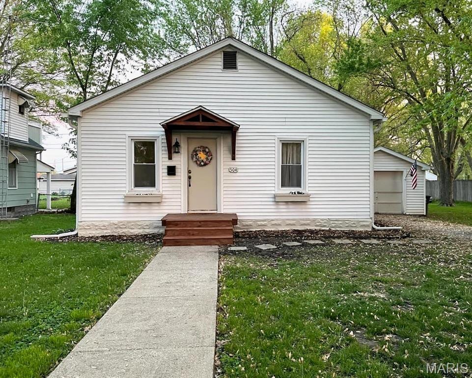 504 Henrietta St, Gillespie, IL 62033 - bungalow-style home featuring a front lawn, a garage, and an outdoor structure