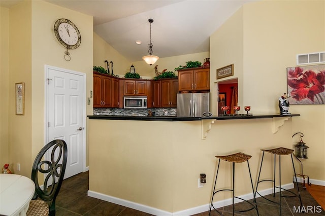9574 Woodcrest Pl, Breese, IL 62230 - kitchen featuring appliances with stainless steel finishes, dark countertops, a kitchen breakfast bar, lofted ceiling, and decorative backsplash
