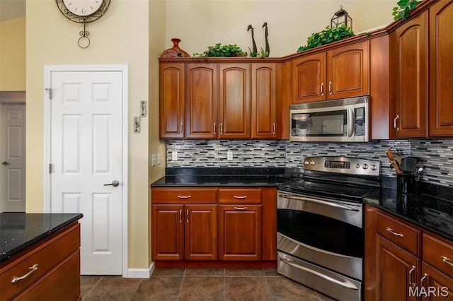 9574 Woodcrest Pl, Breese, IL 62230 - kitchen featuring appliances with stainless steel finishes, backsplash, dark tile patterned floors, dark stone countertops, and baseboards