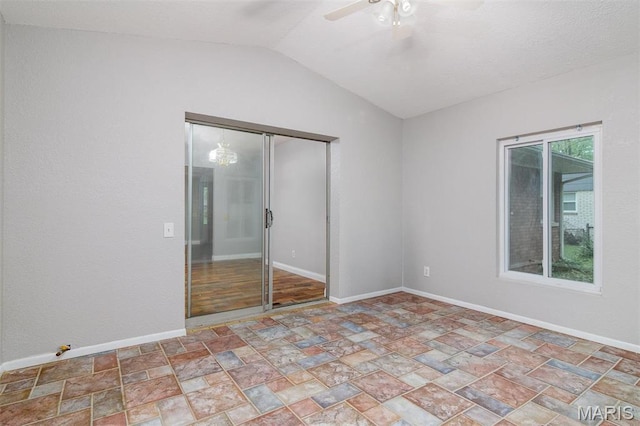 213 Joseph Dr, Fairview Heights, IL 62208 - spare room featuring stone finish flooring, a ceiling fan, vaulted ceiling, and baseboards