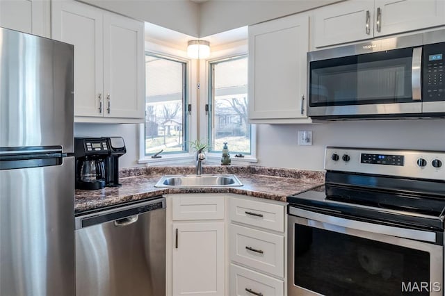 729 W State St, Union, MO 63084 - kitchen featuring appliances with stainless steel finishes, a sink, dark countertops, and white cabinets