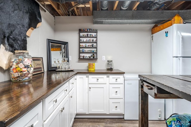729 W State St, Union, MO 63084 - kitchen with freestanding refrigerator, wood finished floors, white cabinetry, and wood counters