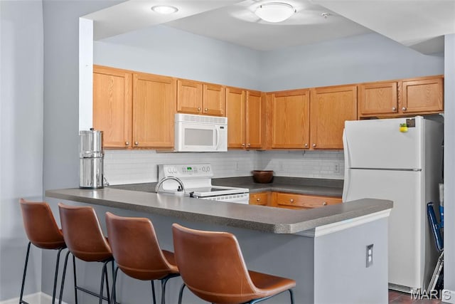 1239 Gardens Circle Dr Unit I, Saint Louis, MO 63125 - kitchen with white appliances, a peninsula, dark countertops, and backsplash