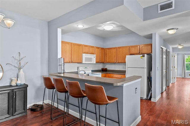 1239 Gardens Circle Dr Unit I, Saint Louis, MO 63125 - kitchen featuring white appliances, a peninsula, dark countertops, tasteful backsplash, and a breakfast bar
