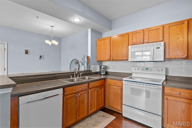 1239 Gardens Circle Dr Unit I, Saint Louis, MO 63125 - kitchen featuring white appliances, a sink, dark countertops, a chandelier, and dark wood-style flooring