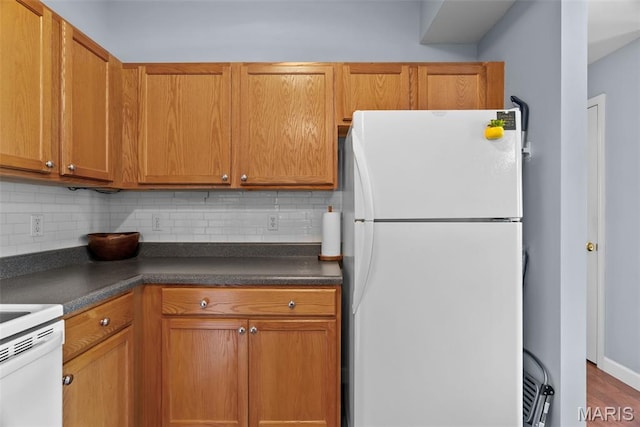 1239 Gardens Circle Dr Unit I, Saint Louis, MO 63125 - kitchen featuring freestanding refrigerator, dark countertops, backsplash, and brown cabinetry