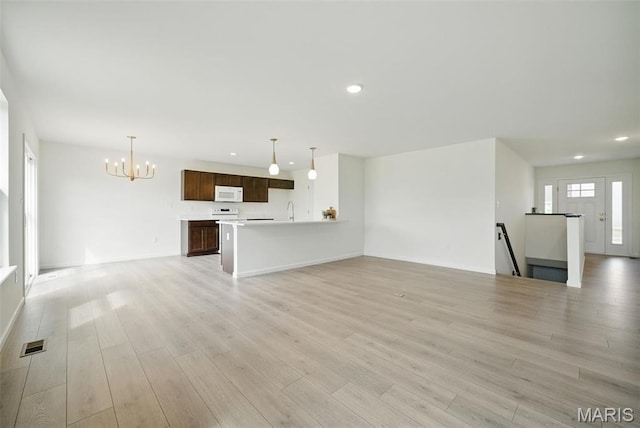 114 Harrow Dr, Ofallon, MO 63385 - unfurnished living room with recessed lighting, a chandelier, light wood-style flooring, a sink, and baseboards