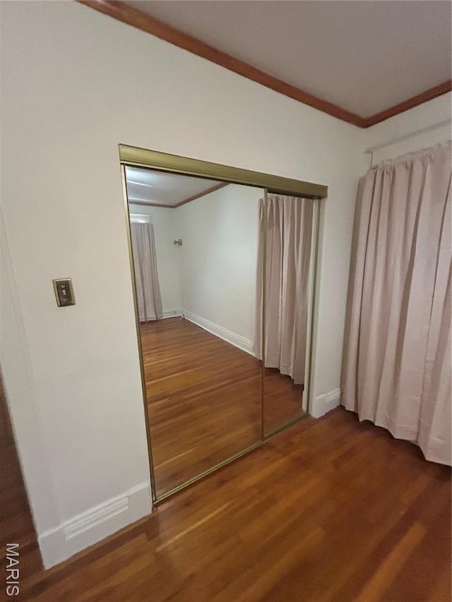 740 Heman Ave, Saint Louis, MO 63130 - unfurnished bedroom featuring wood finished floors, ornamental molding, and baseboards