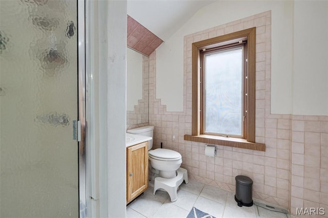 5245 Robert Ave, Saint Louis, MO 63109 - bathroom featuring vaulted ceiling, a stall shower, tile walls, tile patterned flooring, and toilet
