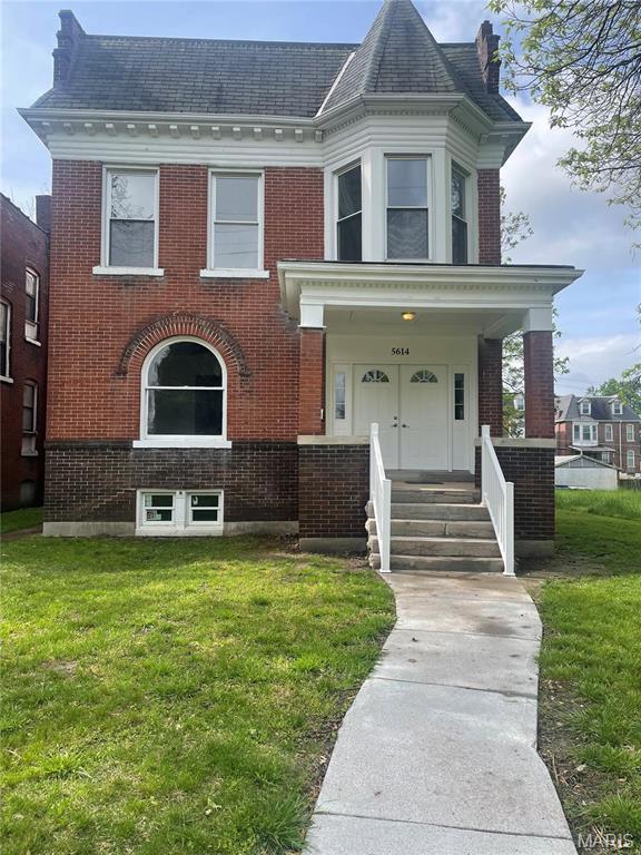 5614 Etzel Ave, Saint Louis, MO 63112 - view of front of property with brick siding, a front lawn, and a shingled roof
