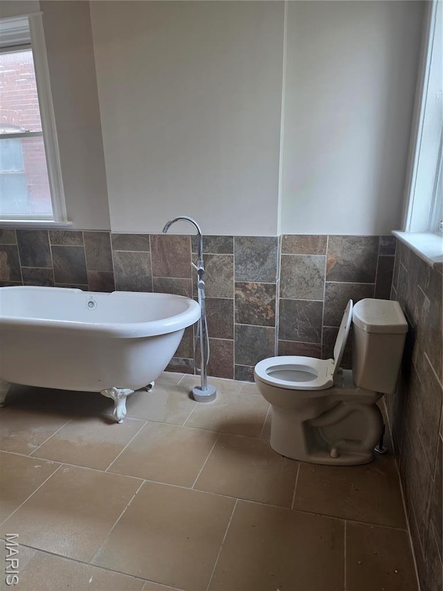 5614 Etzel Ave, Saint Louis, MO 63112 - bathroom featuring tile walls, toilet, a freestanding bath, and wainscoting