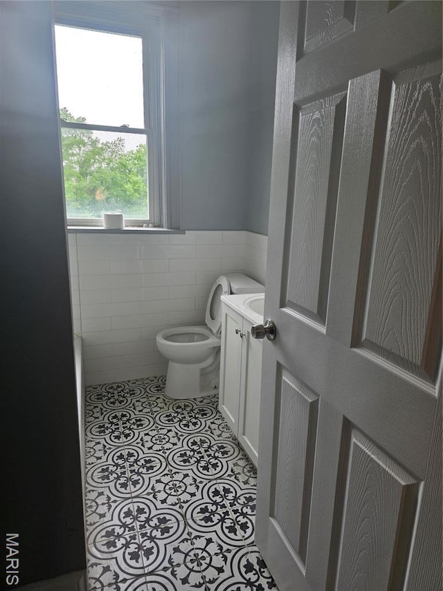 5614 Etzel Ave, Saint Louis, MO 63112 - half bath with toilet, tile walls, a wainscoted wall, and vanity