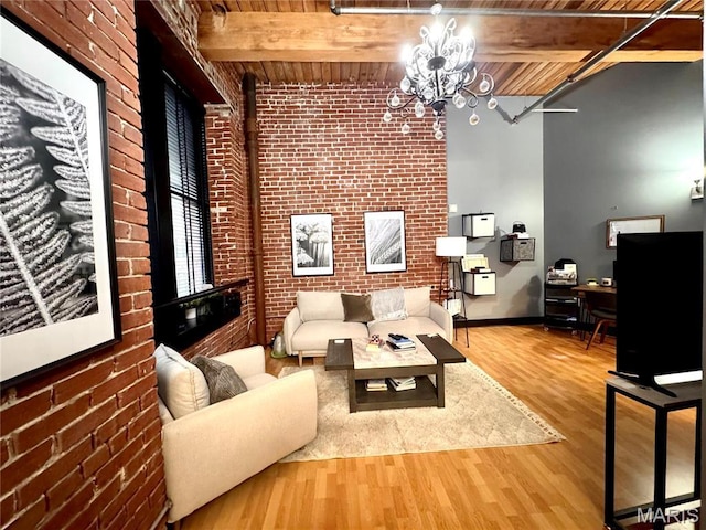 1113 Washington Ave Unit 312, Saint Louis, MO 63101 - living room featuring brick wall, a chandelier, wood ceiling, wood finished floors, and beamed ceiling