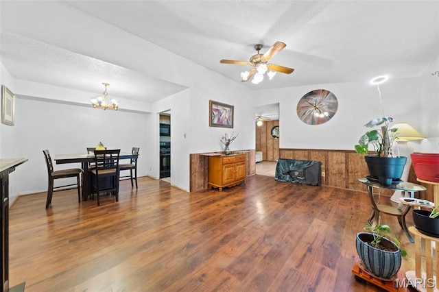 11151 Whispering Oaks Dr, Saint Louis, MO 63136 - living room featuring wood finished floors, a chandelier, a ceiling fan, a wainscoted wall, and wood walls