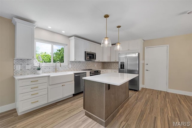 1200 Auber Dr, Manchester, MO 63011 - kitchen featuring appliances with stainless steel finishes, a sink, backsplash, light wood-style floors, and recessed lighting