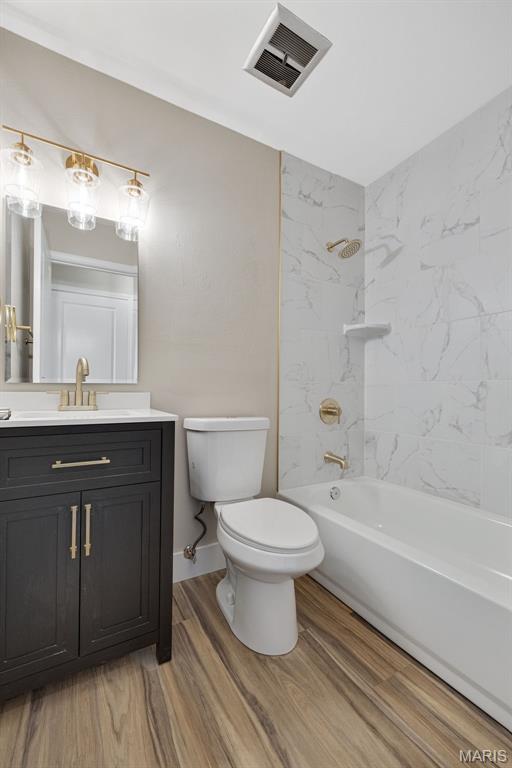 1200 Auber Dr, Manchester, MO 63011 - full bath featuring toilet, wood finished floors, vanity, and  shower combination