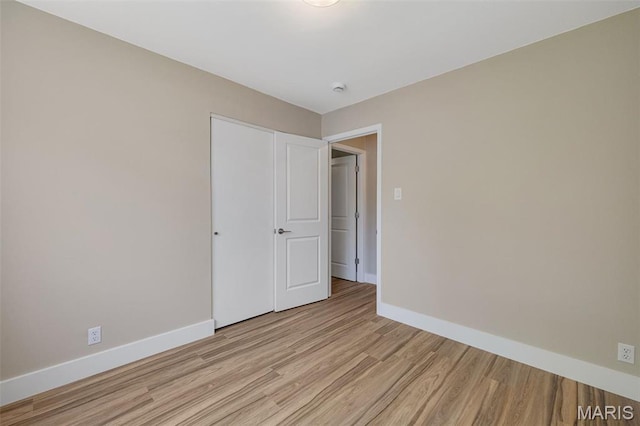 1200 Auber Dr, Manchester, MO 63011 - unfurnished bedroom with light wood finished floors, baseboards, and a closet