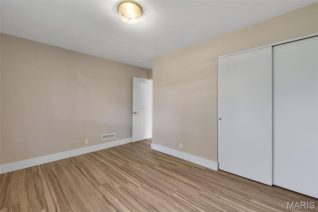 1200 Auber Dr, Manchester, MO 63011 - unfurnished bedroom featuring light wood finished floors, baseboards, and a closet