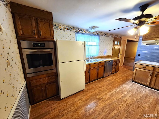 4241 State Route 162, Granite City, IL 62040 - kitchen featuring wallpapered walls, stainless steel appliances, a sink, light wood-style floors, and exhaust hood