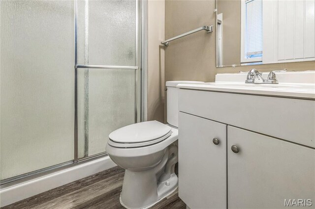 6363 Coventry Dr, Florissant, MO 63033 - bathroom featuring a stall shower, vanity, toilet, and wood finished floors