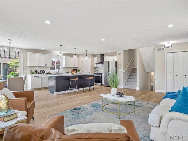 496 E 2nd St, Trenton, IL 62293 - living area with light wood-style flooring, a chandelier, recessed lighting, baseboards, and stairway