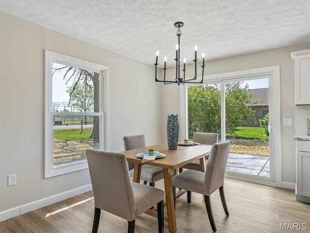 496 E 2nd St, Trenton, IL 62293 - dining area with a chandelier, healthy amount of natural light, baseboards, light wood finished floors, and a textured ceiling