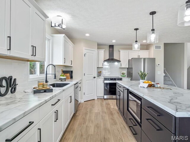 496 E 2nd St, Trenton, IL 62293 - kitchen with wall chimney exhaust hood, appliances with stainless steel finishes, a sink, white cabinetry, and backsplash