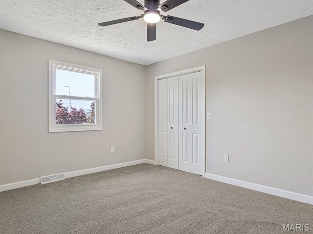 496 E 2nd St, Trenton, IL 62293 - unfurnished bedroom featuring a textured ceiling, a closet, baseboards, and carpet floors