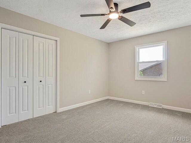 496 E 2nd St, Trenton, IL 62293 - unfurnished bedroom with a textured ceiling, carpet flooring, baseboards, a closet, and ceiling fan