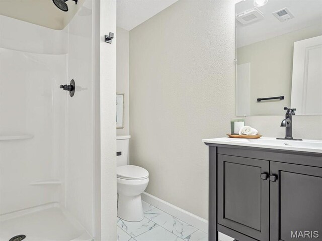 496 E 2nd St, Trenton, IL 62293 - bathroom featuring a stall shower, vanity, marble look tiles, and toilet