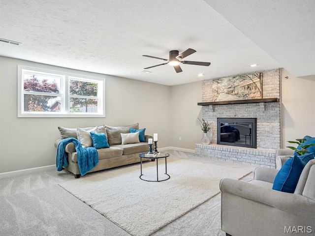 496 E 2nd St, Trenton, IL 62293 - carpeted living area with baseboards, a ceiling fan, a fireplace, and a textured ceiling