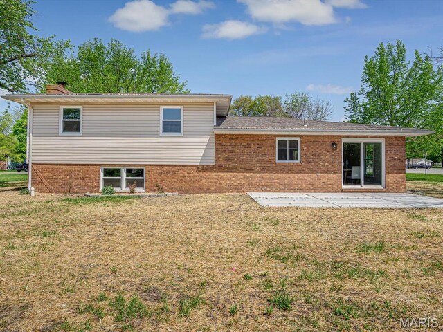 496 E 2nd St, Trenton, IL 62293 - rear view of property featuring a patio, brick siding, a lawn, and a chimney