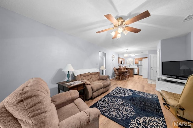 12944 Bryce Canyon Dr, Maryland Heights, MO 63043 - living area featuring light wood-style floors, a ceiling fan, and a chandelier